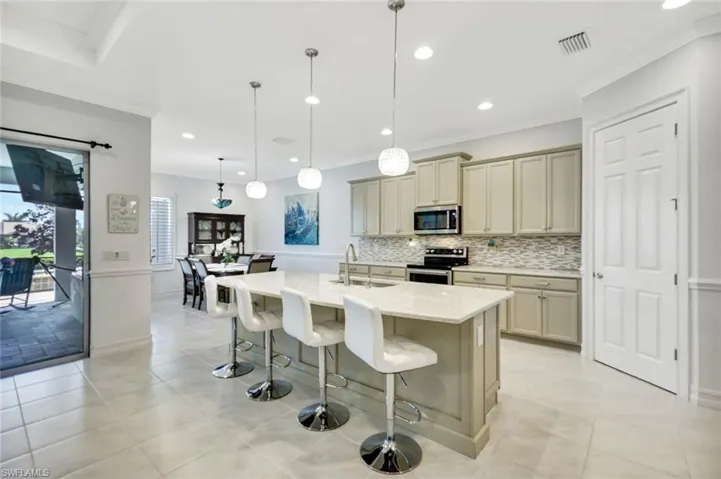 Kitchen with visible vents, decorative backsplash, appliances with stainless steel finishes, a breakfast bar, and a sink