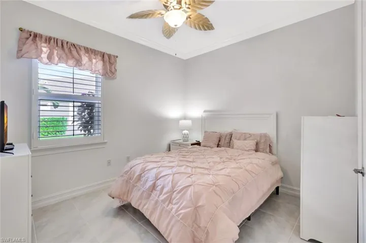 Bedroom featuring light tile patterned floors, baseboards, and ornamental molding