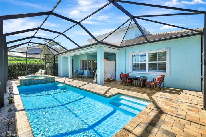 View of swimming pool featuring a patio and a pool with connected hot tub