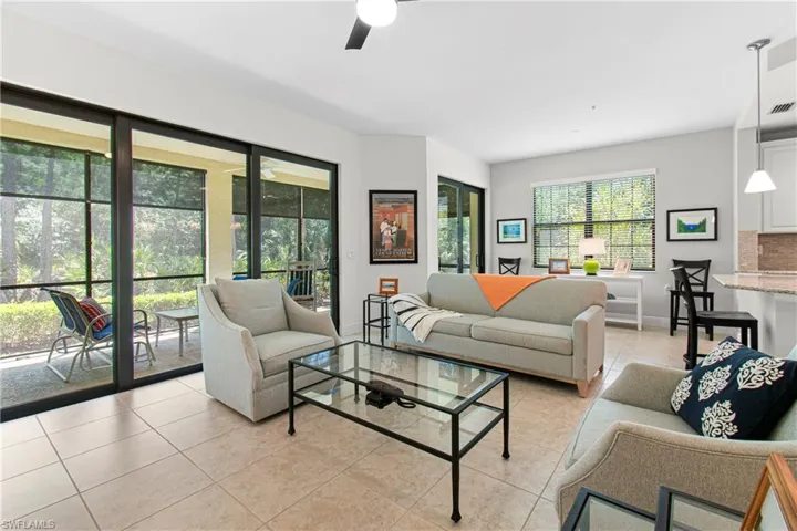 LARGE LIVING ROOM WITH TRIPLE IMPACT SLIDER STACKING DOORS TO THE LANAI.