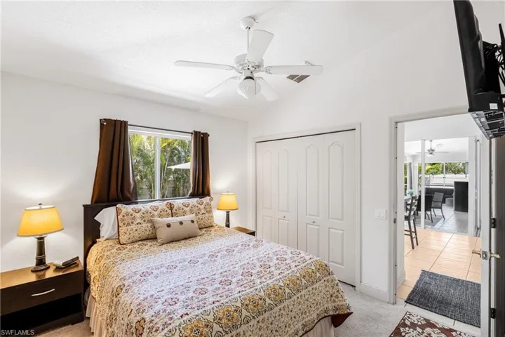 Bedroom with light colored carpet, ceiling fan, lofted ceiling, and a closet