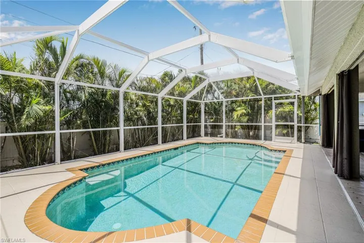 Outdoor pool with glass enclosure and a patio area