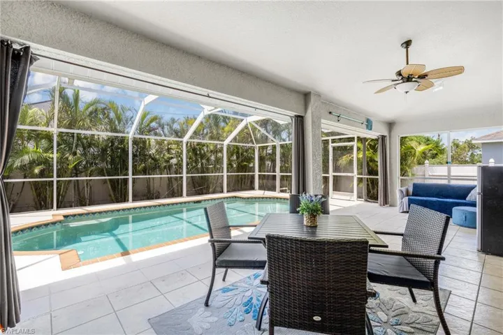 View of pool with a fenced in pool, a lanai, a patio, and ceiling fan