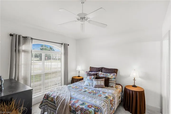 Carpeted bedroom featuring a ceiling fan