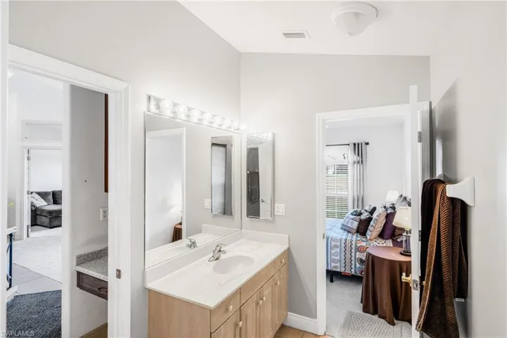 Ensuite bathroom with vanity, baseboards, ensuite bathroom, and visible vents