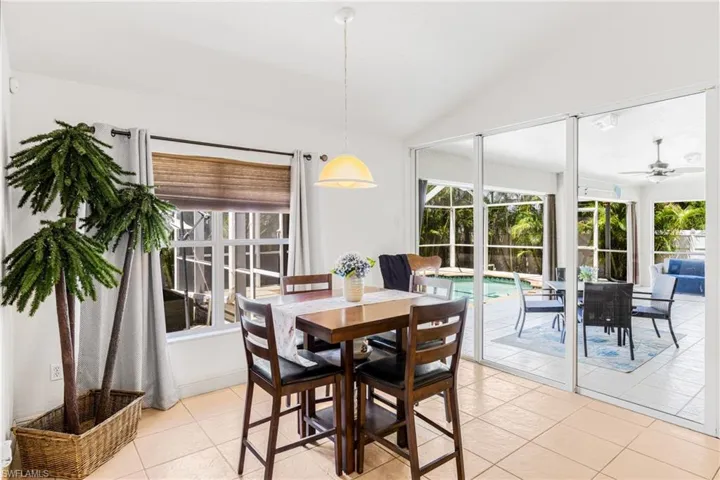 Dining room featuring light tile patterned floors, lofted ceiling, a ceiling fan, and a wealth of natural light