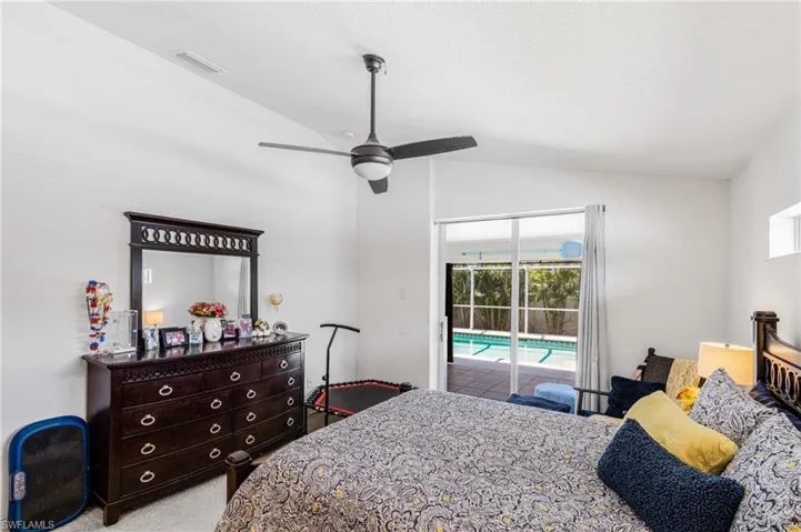 Primary Bedroom featuring ceiling fan, light carpet, lofted ceiling, access to exterior, and visible vents