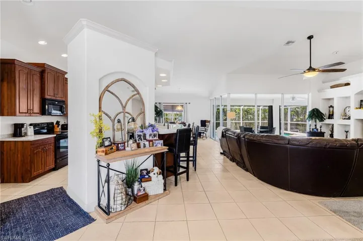 Living area featuring a ceiling fan, visible vents, a wealth of natural light, and light tile patterned floors