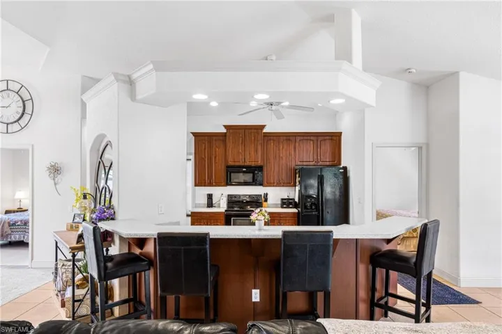Kitchen with light countertops, black appliances, and light tile patterned flooring