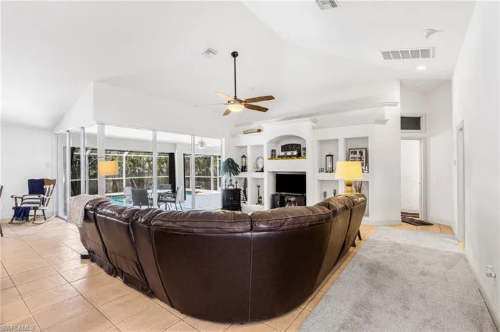 Living area featuring a ceiling fan, visible vents, a fireplace, and light tile patterned flooring
