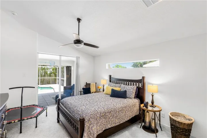 Primary Bedroom featuring lofted ceiling, visible vents, a ceiling fan, access to exterior, and carpet floors