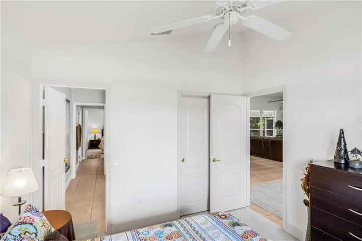 Bedroom featuring high vaulted ceiling, ceiling fan, and light tile patterned flooring