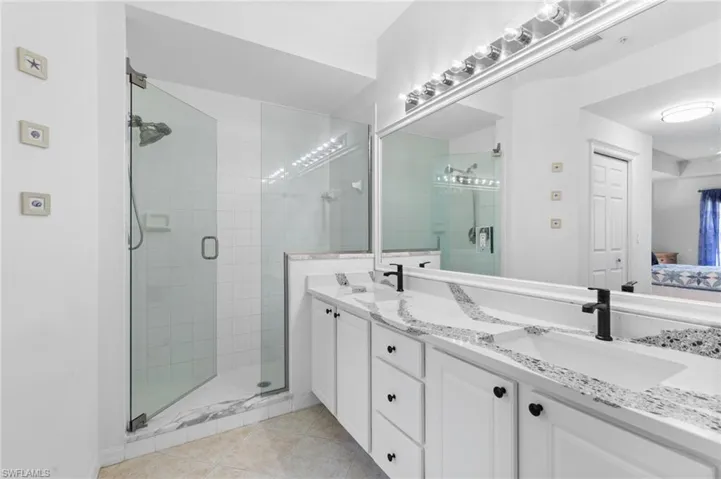 Bathroom featuring vanity, an enclosed shower, and tile patterned flooring