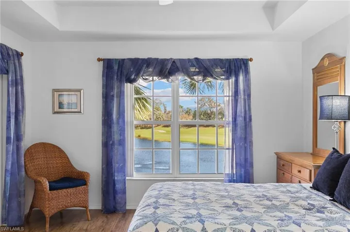 Bedroom featuring a raised ceiling and wood-type flooring