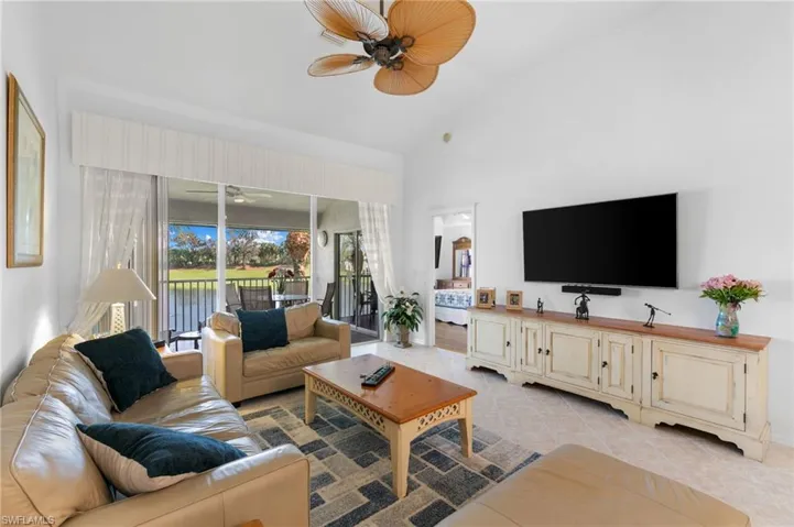 Tiled living room with high vaulted ceiling and ceiling fan