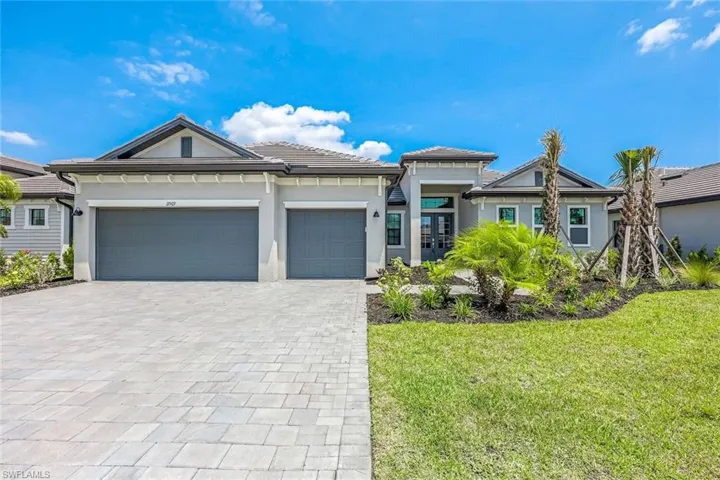 View of front facade featuring a garage and a front yard