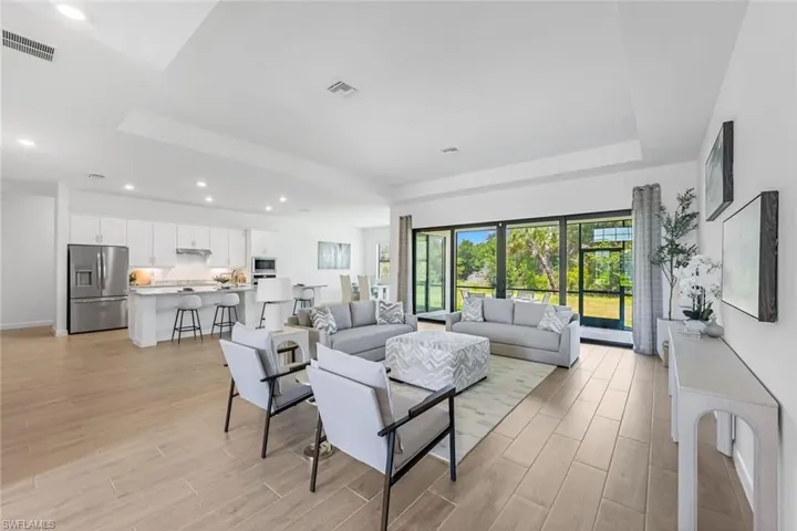 Living room featuring a tray ceiling and light wood-type flooring