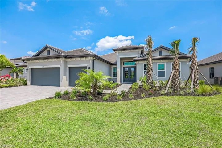 View of front of home featuring a front yard, a garage, and central AC
