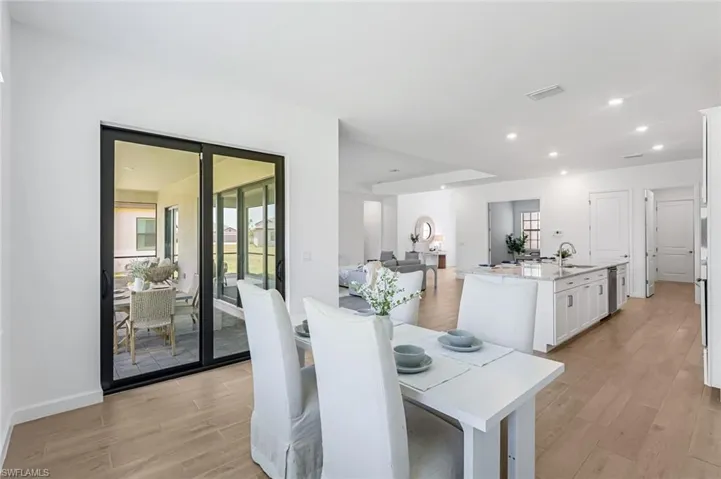 Dining area featuring sink, plenty of natural light, and light wood-type flooring