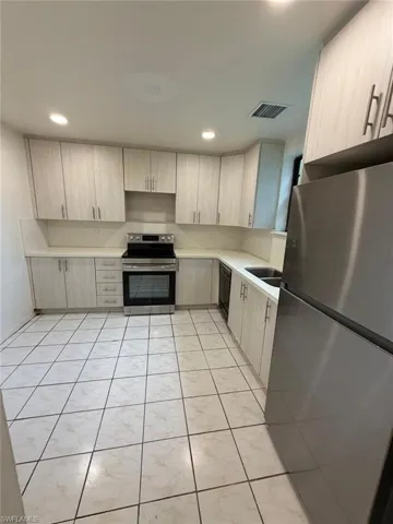 Kitchen featuring light-toned cabinetry, light countertops, and a tiled floor