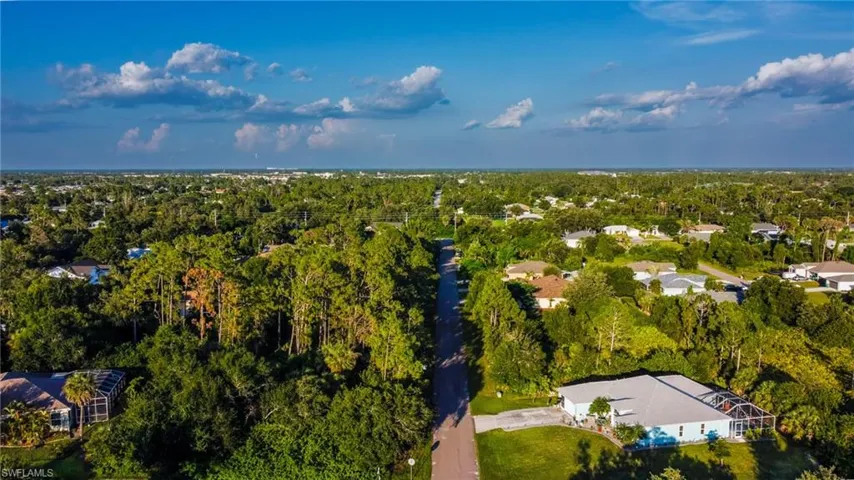 Aerial view of property and surrounding area with a heavily wooded area