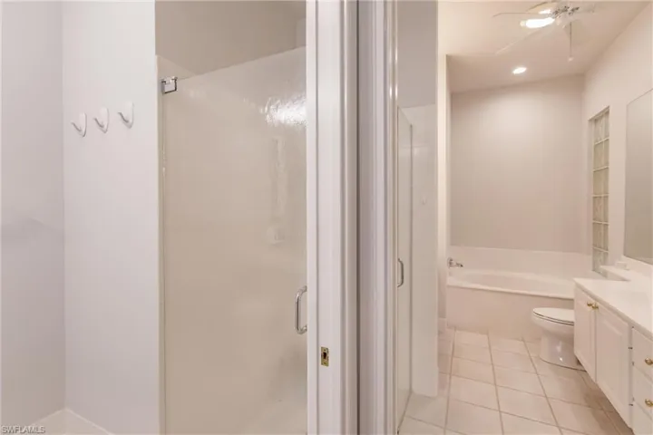 Full bathroom with vanity, separate shower and tub, ceiling fan, and tile patterned floors