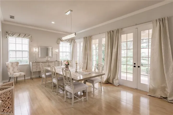 Dining space featuring ornamental molding, light hardwood / wood-style floors, and french doors