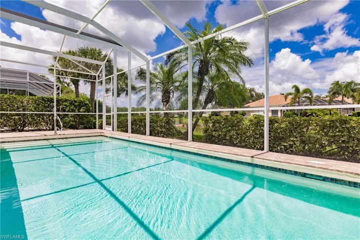 View of swimming pool featuring glass enclosure