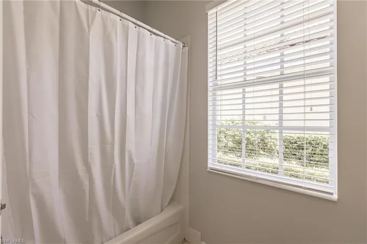 Bathroom featuring plenty of natural light and shower / bath combo with shower curtain