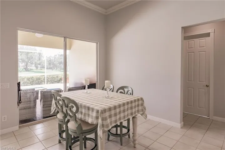 Dining space with crown molding and light tile patterned flooring