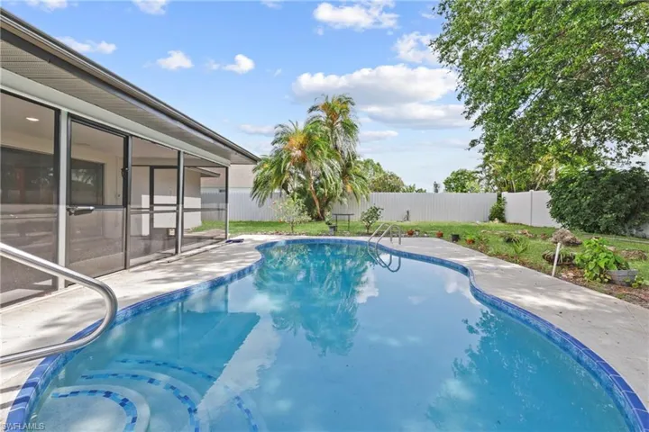 View of swimming pool with a fenced backyard, a sunroom, and a patio