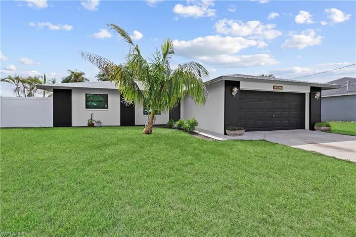 View of front facade featuring driveway, an attached garage, and stucco siding