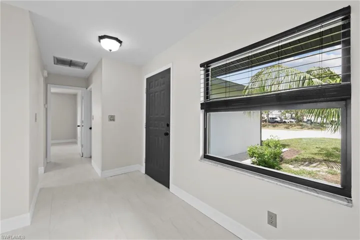 Foyer entrance with healthy amount of natural light and marble look tile flooring
