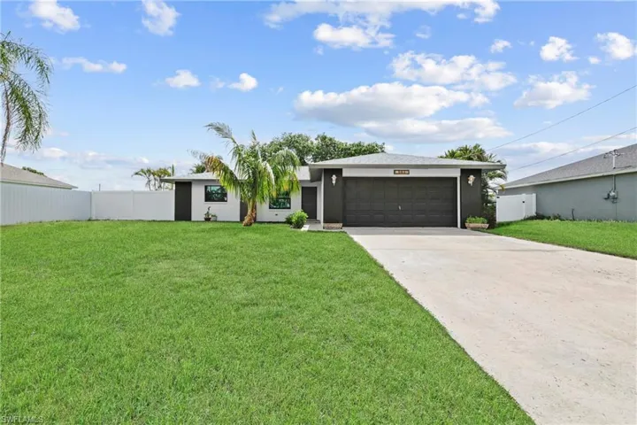 View of front facade featuring an attached garage, driveway, and stucco siding