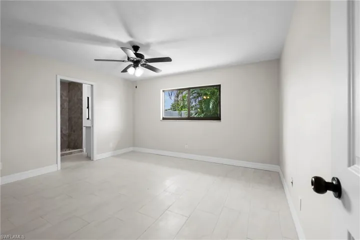 Unfurnished room featuring a ceiling fan and baseboards