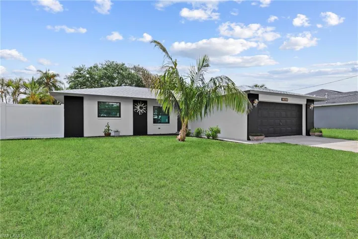 View of front of property with driveway, an attached garage, and stucco siding