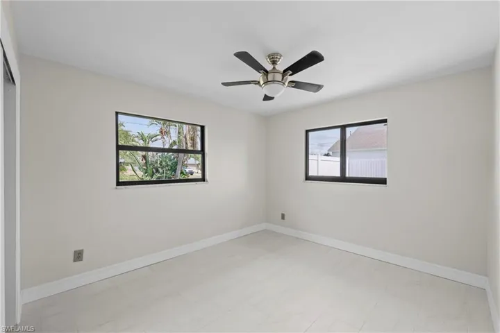 Unfurnished room with baseboards and ceiling fan