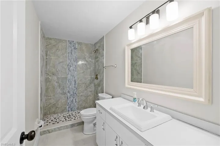 Bathroom featuring vanity and a tile shower