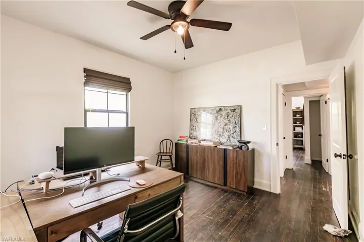 Office area with ceiling fan and dark hardwood / wood-style flooring