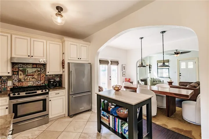 Kitchen with appliances with stainless steel finishes, decorative backsplash, cream cabinets, and plenty of natural light