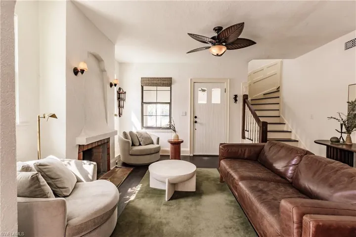 Living room with dark hardwood / wood-style floors, a fireplace, and ceiling fan