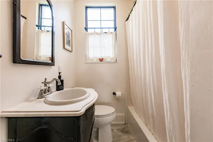 Full bathroom featuring toilet, vanity, and shower / bath combination with curtain