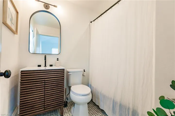 Bathroom featuring vanity, toilet, tile patterned floors, and curtained shower