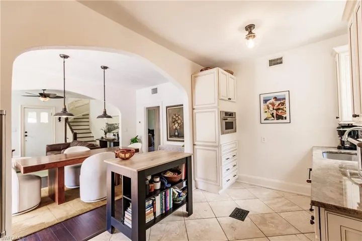 Kitchen with oven, sink, ceiling fan, pendant lighting, and dark stone countertops