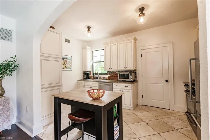 Kitchen featuring sink, dishwasher, and cream cabinets