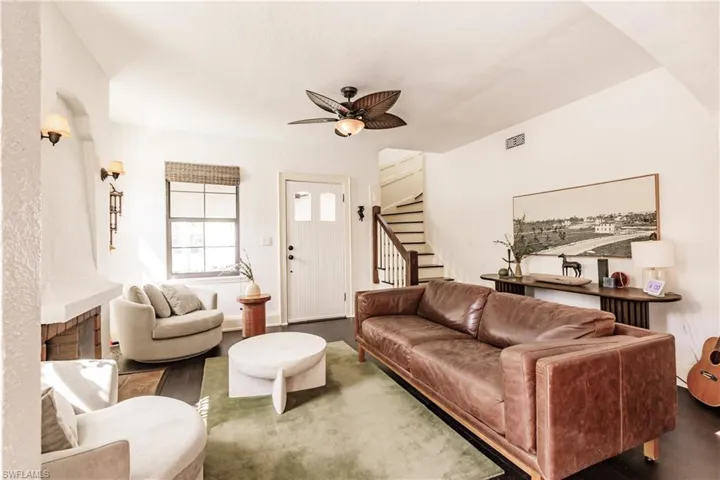 Living room with dark wood-type flooring and ceiling fan