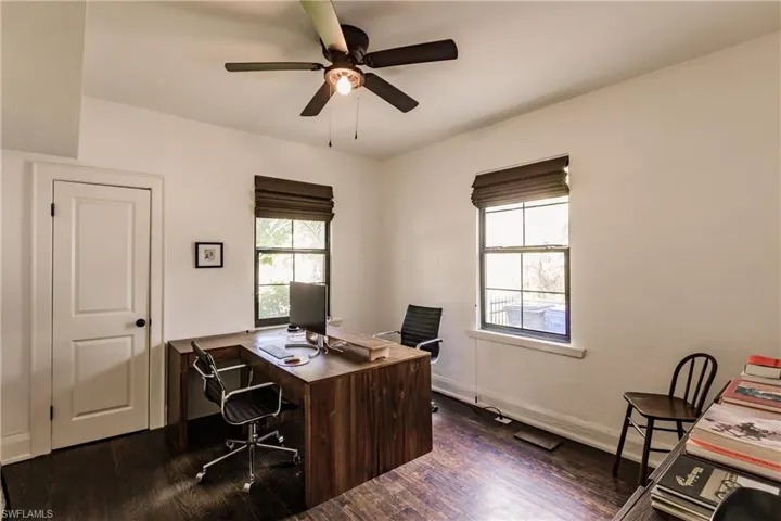 Office space with ceiling fan and dark hardwood / wood-style flooring