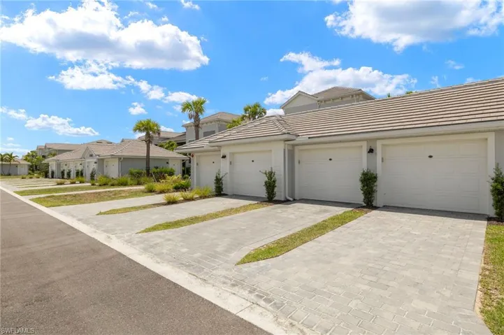 Multi unit property with a tile roof, community garages, a residential view, and stucco siding