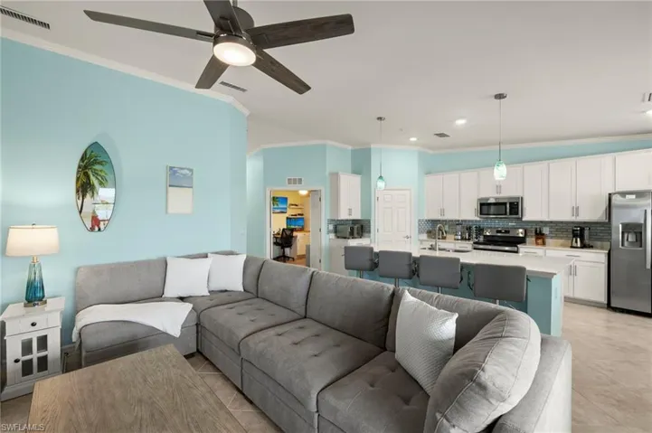 Living room featuring crown molding and a ceiling fan