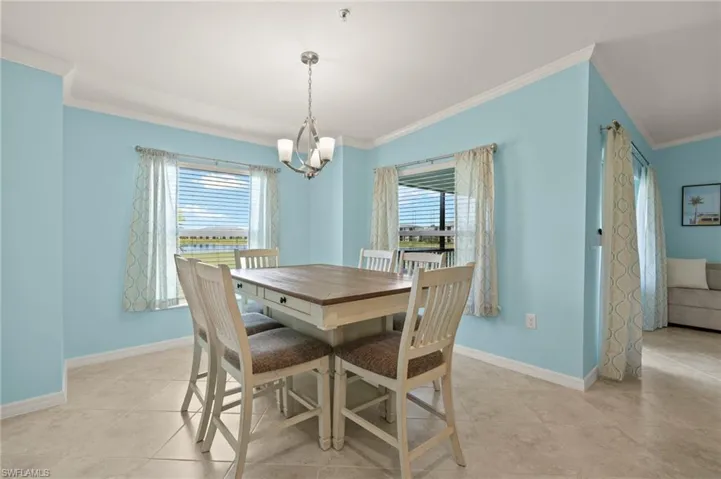 Dining space with a chandelier, ornamental molding, plenty of natural light, and baseboards